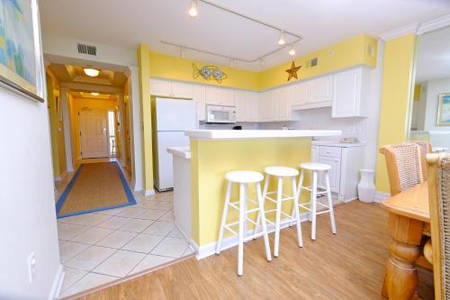 a kitchen with a counter and stools in it at Litchfield Beach & Golf Resort in Pawleys Island