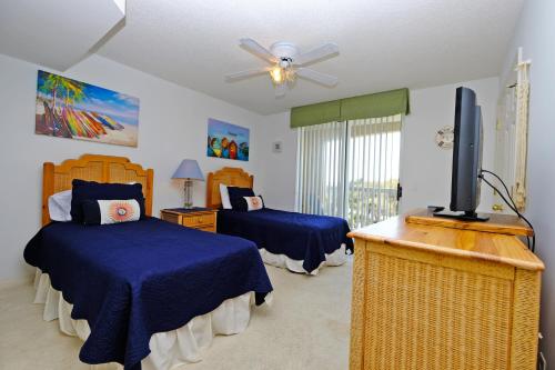a bedroom with two beds and a flat screen tv at Litchfield Beach & Golf Resort in Pawleys Island