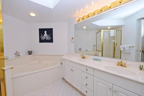 a white bathroom with a tub and a sink at Litchfield Beach & Golf Resort in Pawleys Island