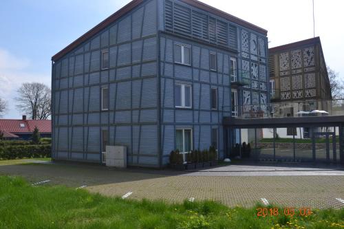 un gran edificio negro con piso Aveth en Miško apartamentai 50m2, en Juodkrantė