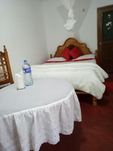 a bedroom with two beds with a bottle of water on top at Homeaway Homestay Hatton in Hatton
