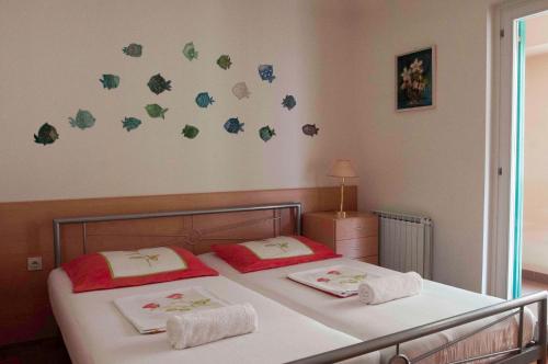 two beds in a bedroom with butterflies on the wall at Spacious balcony apartment Piran in Piran
