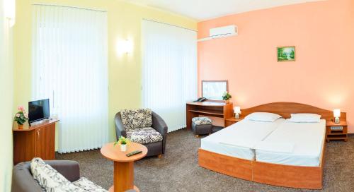 ヴァルナ・シティにあるFamily Hotel Varnaのベッド1台と椅子2脚が備わるホテルルームです。