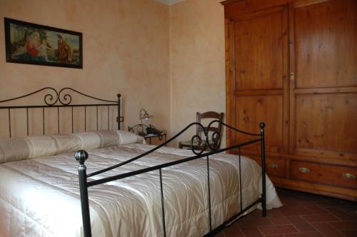a bedroom with a bed and a wooden cabinet at Piccolo Hotel San Valentino in Cristena