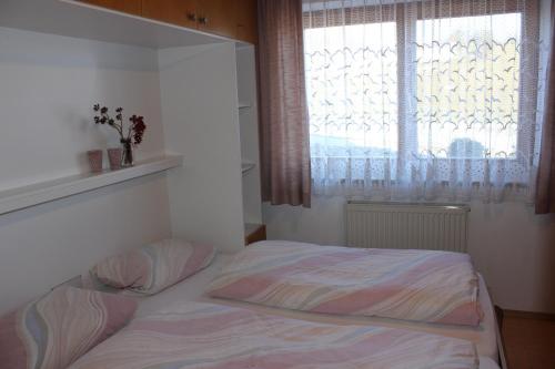 a small bedroom with a bed with a window at Haus Spiessl in Bad Griesbach
