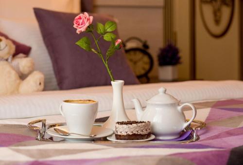 a table with two cups and a vase with a flower at Park Hotel Warshawskiy in Sarny