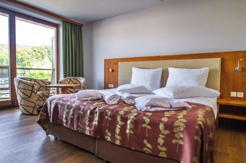 ein Schlafzimmer mit einem großen Bett mit Handtüchern darauf in der Unterkunft HOTEL Bioterme Mala Nedelja in Ljutomer