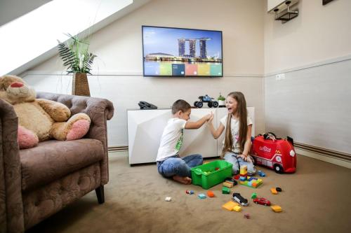 a young girl and boy playing with toys in a living room at Park Hotel Warshawskiy in Sarny