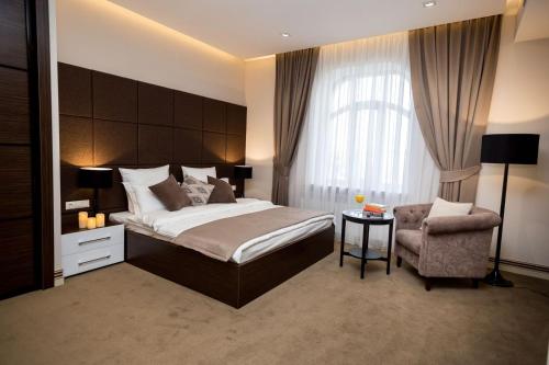 a bedroom with a large bed and a chair at Park Hotel Warshawskiy in Sarny