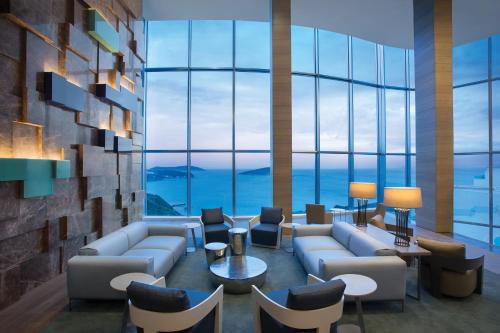 a lobby with couches and tables and large windows at Sirene Luxury Hotel Bodrum in Yalıkavak