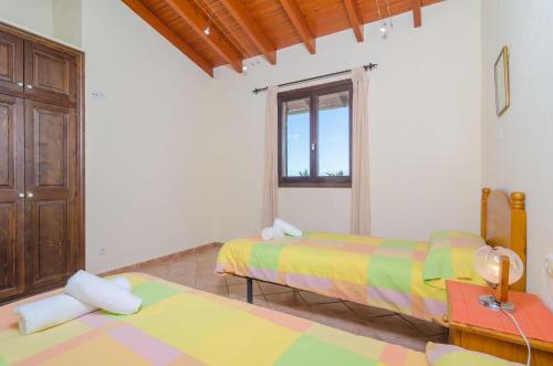a bedroom with two beds and a window at S'Alqueria in Campanet