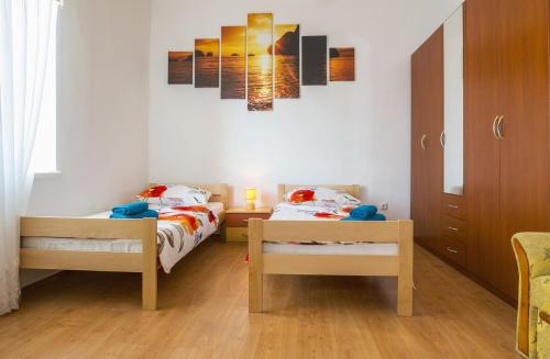 a bedroom with two beds and a painting on the wall at Apartment Stefania on the beach in Koromačno