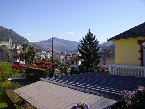 a roof of a house with mountains in the background at Hôtel du Clos Fleuri in Lourdes