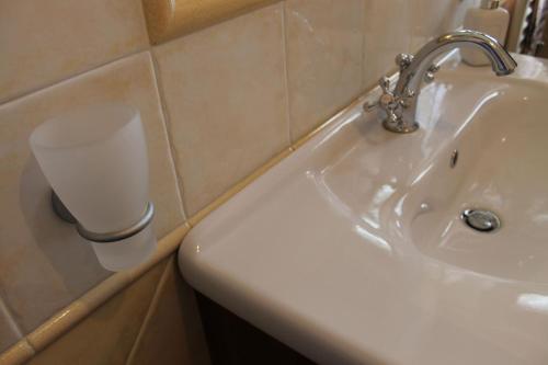a bathroom with a sink and a cup on the wall at Casa Marilì in Pianillo