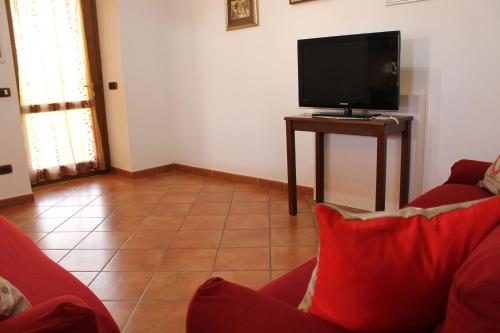 a living room with a red couch and a flat screen tv at Casa Marilì in Pianillo