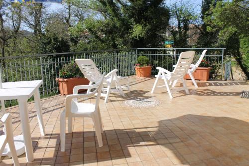 a group of white chairs sitting on a patio at Casa Marilì in Pianillo