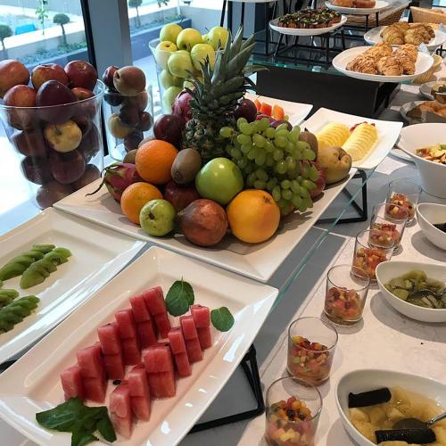 a table with several plates of fruits and vegetables at Wyndham Doha West Bay in Doha