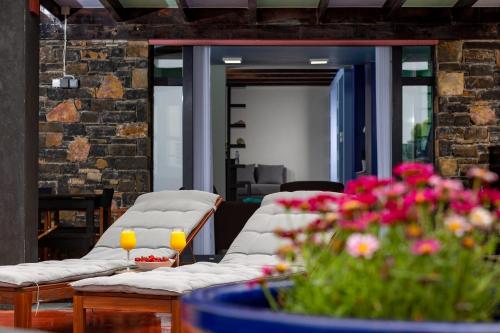 a room with two couches and a table with flowers at Villa Menelaos in Mochlos
