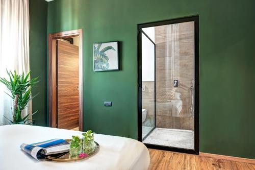 - une chambre avec un mur vert et un miroir dans l'établissement Carusotto - Sorrento, à Sorrente