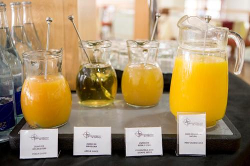 four glass pitchers of orange juice on a table at Gran Hotel de Ferrol in Ferrol
