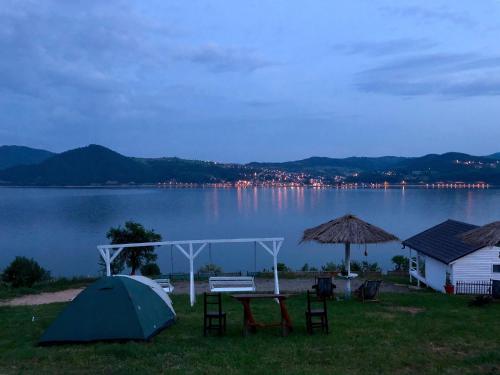 a tent and a table and chairs next to a lake at Dream Tricule in Sviniţa