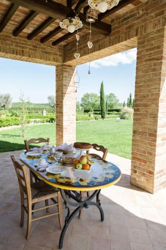 a table with a bowl of fruit on a patio at Podere San Giuseppe in Castiglione del Lago