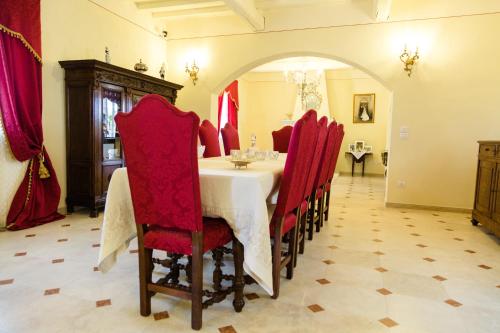 a dining room with a table and red chairs at Podere San Giuseppe in Castiglione del Lago