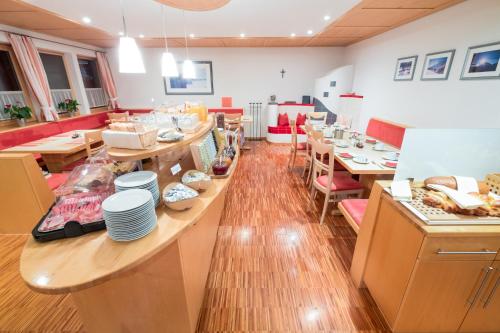 a restaurant with a long table with plates on it at Hotel Garni Krumbach in Damuls