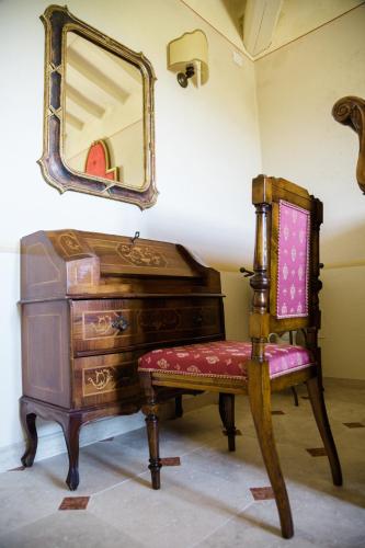 a chair and a dresser with a mirror on the wall at Podere San Giuseppe in Castiglione del Lago