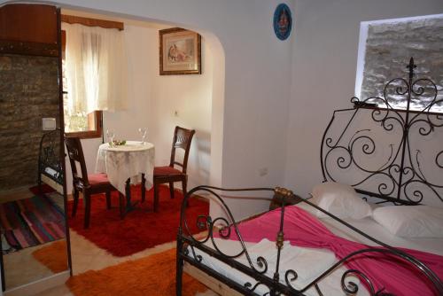 a bedroom with a bed and a table and chairs at Guesthouse Mele in Gjirokastër