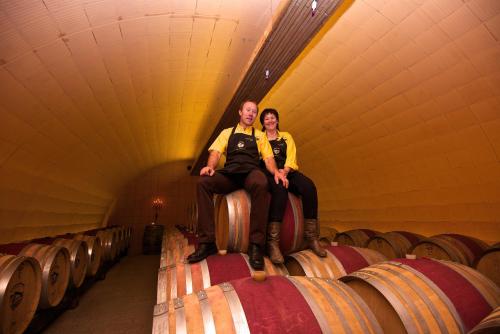 a man and a woman sitting on top of wine barrels at Castel de Daval in Sierre