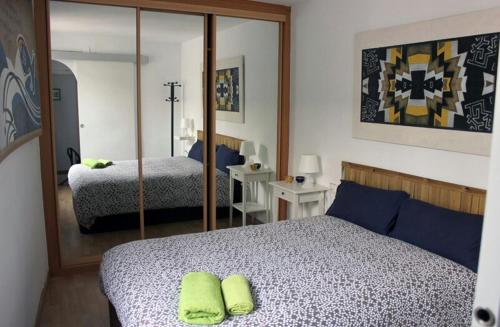 1 dormitorio con cama y espejo en Mini Apartamento Port Aiguadolç, en Sitges