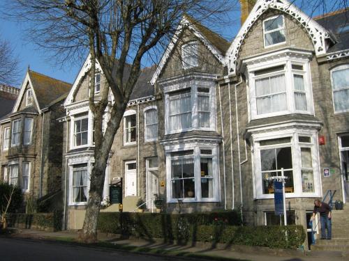 a woman standing in front of a house at Dunedin Guest House in Penzance