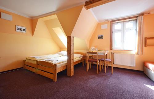a room with two beds and a table in it at Pension Centrum in Špindlerův Mlýn