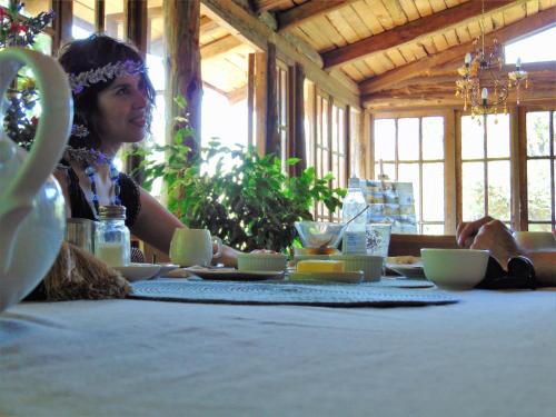 a woman sitting at a table with a table cloth at Cabañas Puente Negro in Puente Negro