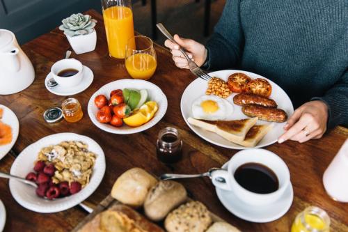 a person sitting at a table with breakfast foods at The Lodge Hotel - Putney in London