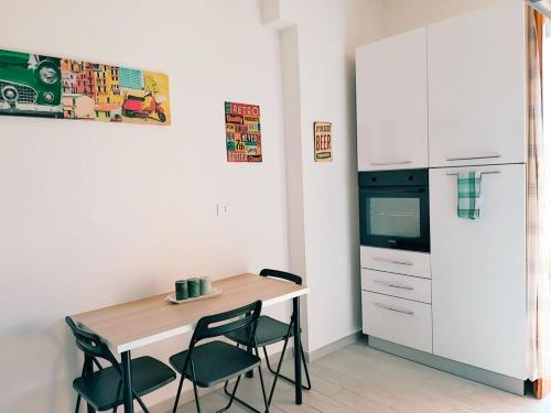 eine Küche mit Tisch und Stühlen und einem Kühlschrank in der Unterkunft La Finestra su San Luca in Bologna