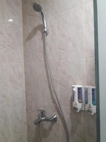 y baño con ducha con cabezal de ducha. en Puji Homestay en Mataram