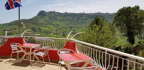 a balcony with chairs and tables with a view of a mountain at B&B ed affittacamere da Pietro in Calascibetta