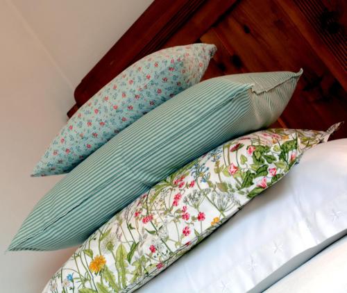 a pile of pillows on top of a bed at APARTMENT im garten 9 in Gargazzone