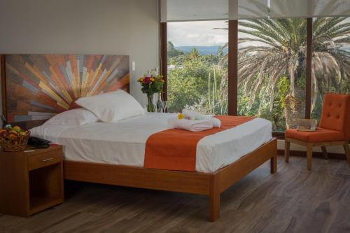 a bedroom with a bed and a large window at Ilalo Garden Hotel & Restaurant in Quito