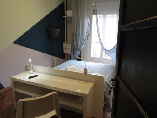 a bedroom with a desk and a bed with a window at Sei Da Noi in Ivrea