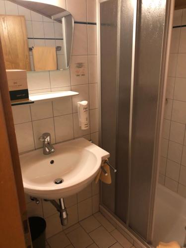 Un pequeño baño con lavabo y ducha. en Hotel Brückenwirt, en Sankt Johann im Pongau