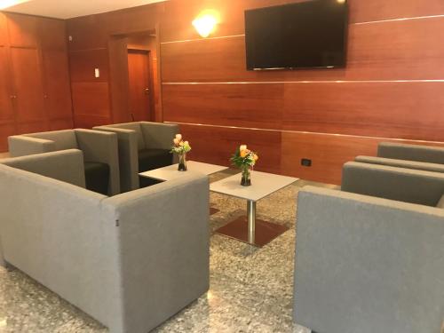 a waiting room with chairs and a flat screen tv at DOMUS Grand Hotel in Rende