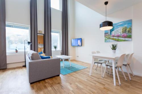 a living room with a couch a table and chairs at ApartDirect Hammarby Sjöstad in Stockholm
