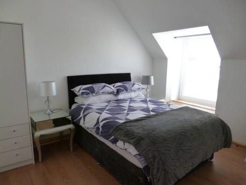 Schlafzimmer mit einem Bett und einem Fenster in der Unterkunft Millburn Apartments in Inverness