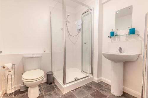 a bathroom with a shower and a toilet and a sink at Five Way Apartments in Paignton