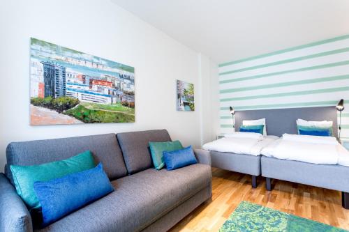 uma sala de estar com um sofá e uma cama em ApartDirect Hammarby Sjöstad em Estocolmo