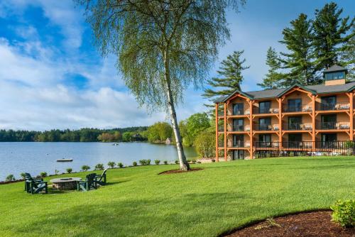 a large building on the shore of a lake at Center Harbor Inn in Center Harbor