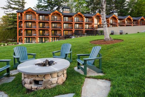 a hotel with three chairs and a fire pit in front of a building at Center Harbor Inn in Center Harbor